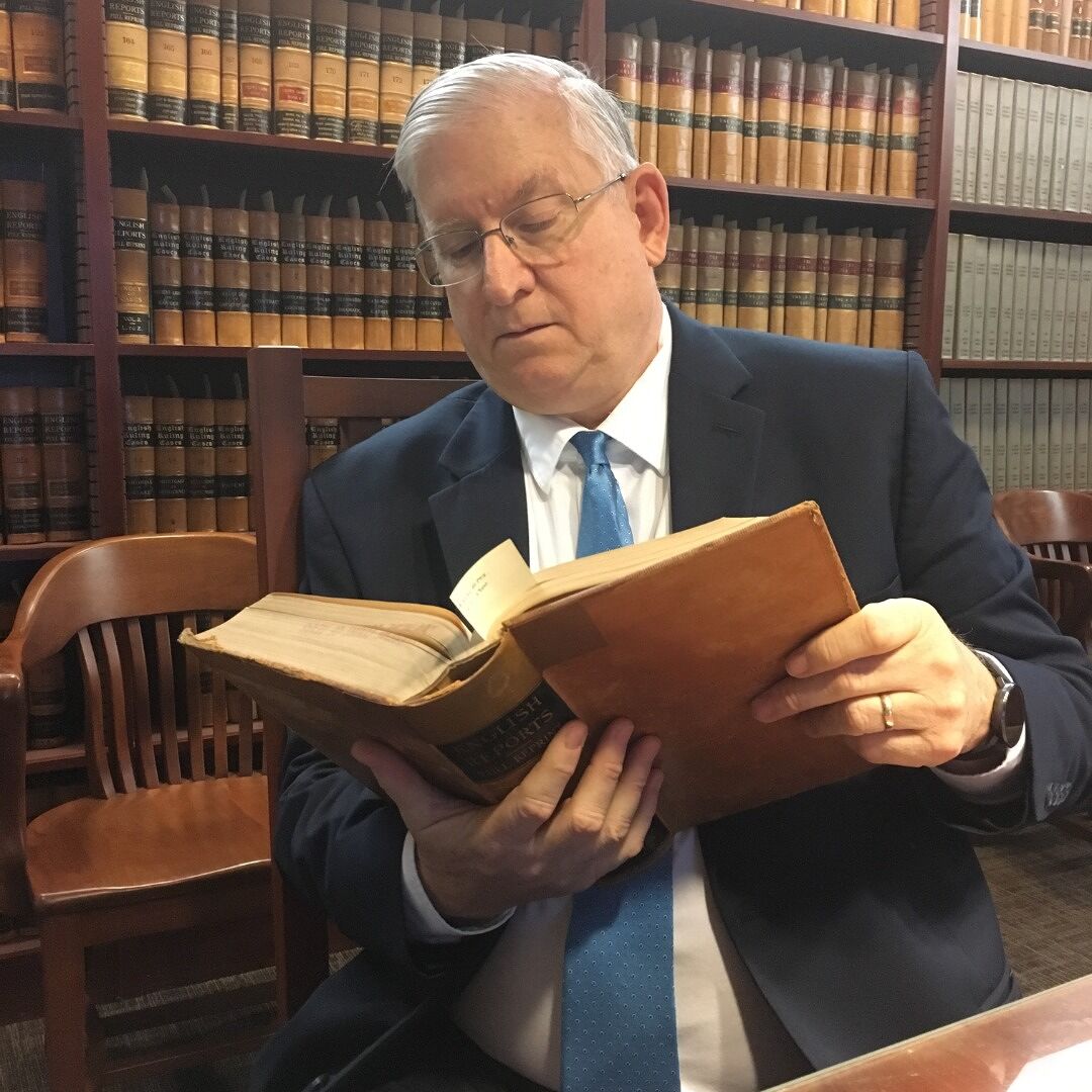 Tom Kimball reading in a law library